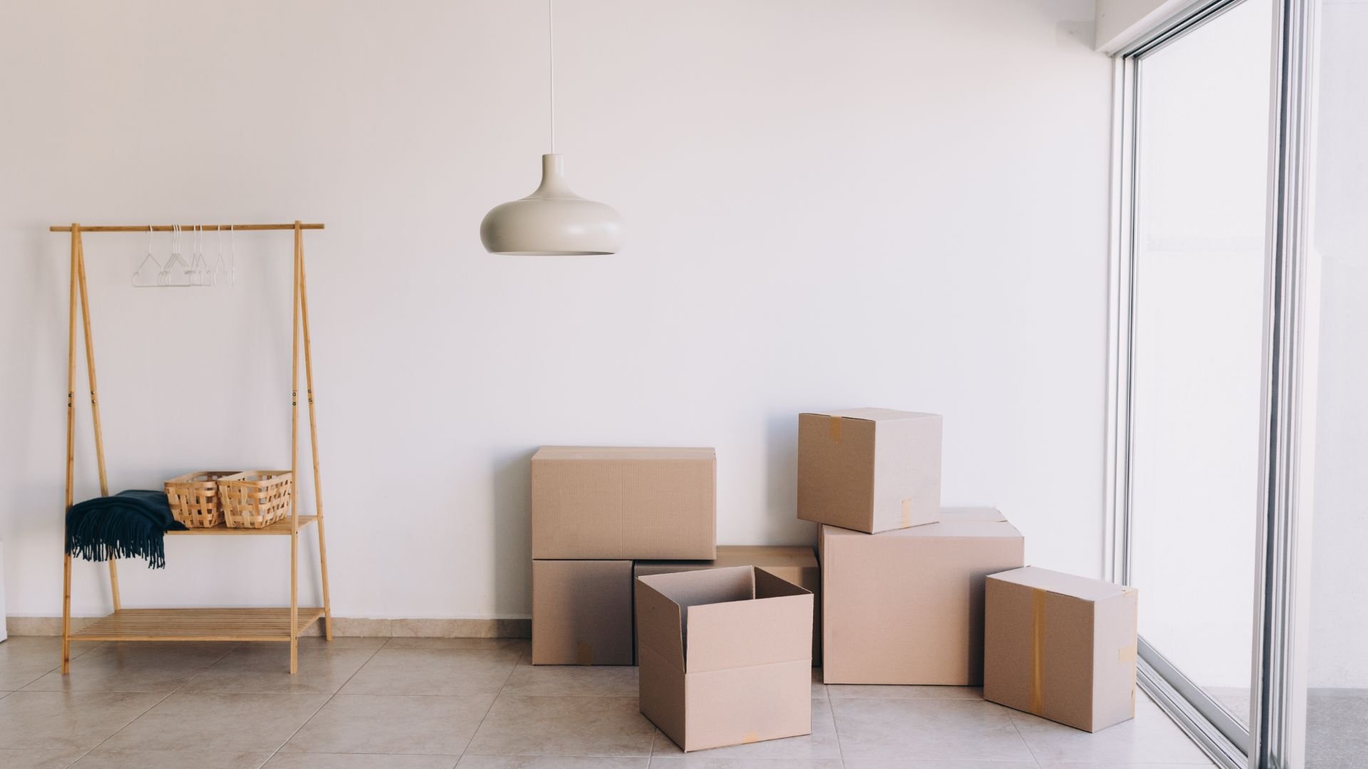 Moving day scene with cardboard boxes, pendant lamp, and wooden shelf