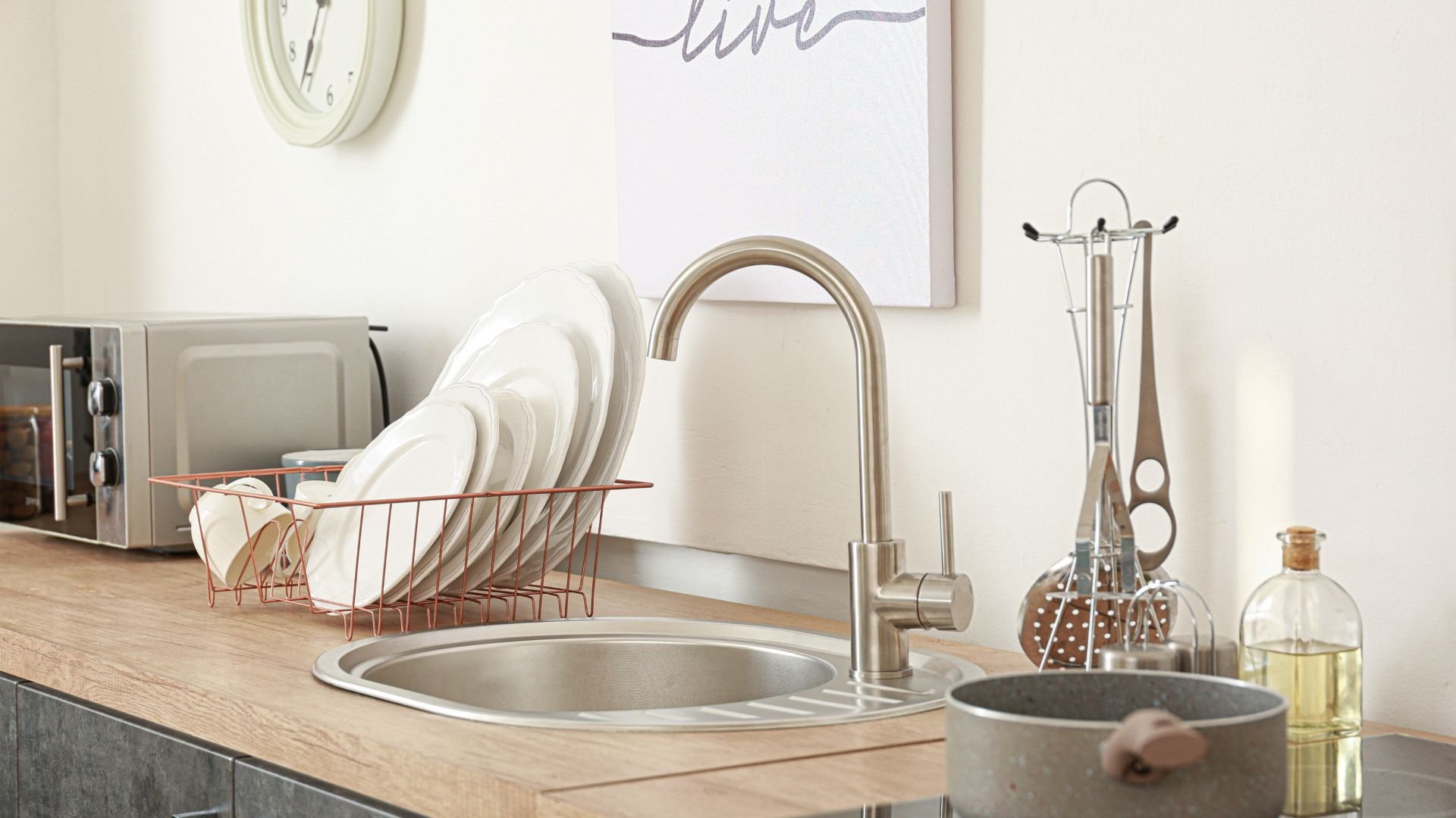 Modern kitchen sink with dishes, faucet, and kitchen accessories